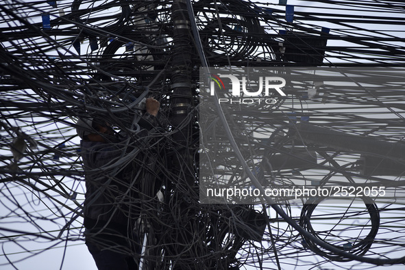 An electrician of Nepal Electricity Authority (NEA) arranging Electric wires at Pulchowk, Patan, Nepal on Tuesday, February 27, 2018. 