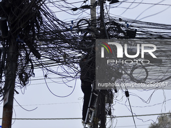 An electrician of Nepal Electricity Authority (NEA) arranging Electric wires at Pulchowk, Patan, Nepal on Tuesday, February 27, 2018. (