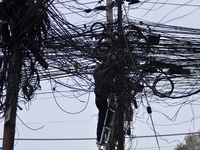 An electrician of Nepal Electricity Authority (NEA) arranging Electric wires at Pulchowk, Patan, Nepal on Tuesday, February 27, 2018. (