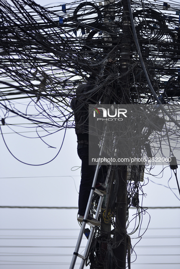 An electrician of Nepal Electricity Authority (NEA) arranging Electric wires at Pulchowk, Patan, Nepal on Tuesday, February 27, 2018. 