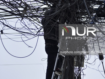 An electrician of Nepal Electricity Authority (NEA) arranging Electric wires at Pulchowk, Patan, Nepal on Tuesday, February 27, 2018. (