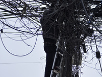 An electrician of Nepal Electricity Authority (NEA) arranging Electric wires at Pulchowk, Patan, Nepal on Tuesday, February 27, 2018. (