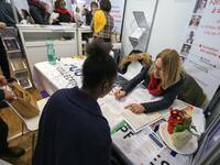 Jobseeker talks with a member of recruitment service at the "Paris pour l'emploi" (Paris for Employment) recruitment forum on March 6, 2018,...