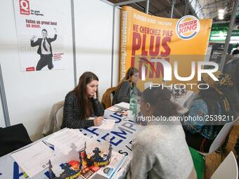 Jobseeker talks with a fast-food’s members of recruitment services at the "Paris pour l'emploi" (Paris for Employment) recruitment forum on...