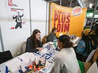 Jobseeker talks with a fast-food’s members of recruitment services at the "Paris pour l'emploi" (Paris for Employment) recruitment forum on...