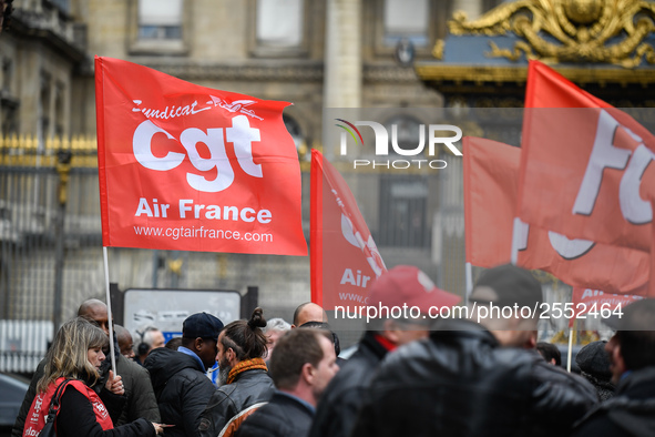 Striking Air France employees hold flags of French union CGT on March 12, 2018 in Paris, during a demonstration in front of the Palace of Ju...