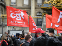 Striking Air France employees hold flags of French union CGT on March 12, 2018 in Paris, during a demonstration in front of the Palace of Ju...