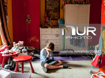 London, Robin at eight years old in his room watching cartoon. (