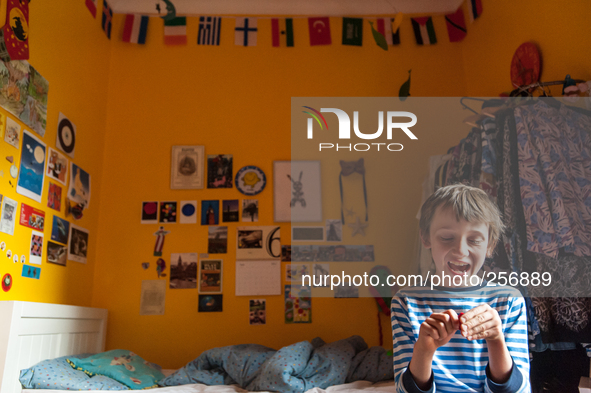 London, Robin at eight years old in his room playing games and shouting out in order to showing off his presence at home to his parents  