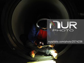 Nepalese Youths using mobile phones as lining in the night to pay the amount for the application submission for the Korean Language Test (KL...