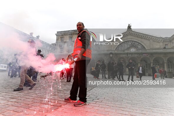 Employee of the French state owned railway company SNCF holds a flare during a demonstration in front of the Gare de l’Est train station on...