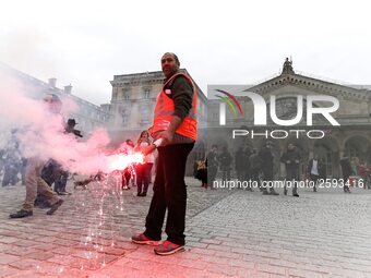 Employee of the French state owned railway company SNCF holds a flare during a demonstration in front of the Gare de l’Est train station on...