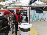 SNCF (French National Railway Corporation) employee speak with travellers to inform them on a platform of the Gare de l’Est railway station...