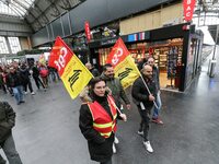 Protestors hold CGT union flags during a demonstration inside the Gare de L'Est train station on April 3, 2018 in Paris, on the first day of...