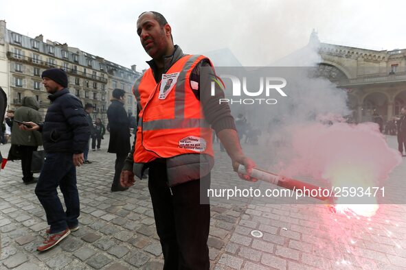 Employee of the French state owned railway company SNCF holds a flare during a demonstration in front of the Gare de l’Est train station on...