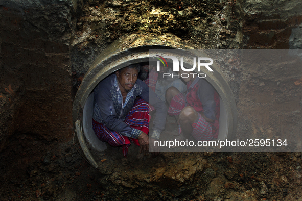 Worker took refuge in an under construction sewerage pipe line while it was raining outside in Dhaka, Bangladesh, on 4 April 2018. 