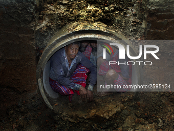 Worker took refuge in an under construction sewerage pipe line while it was raining outside in Dhaka, Bangladesh, on 4 April 2018. (