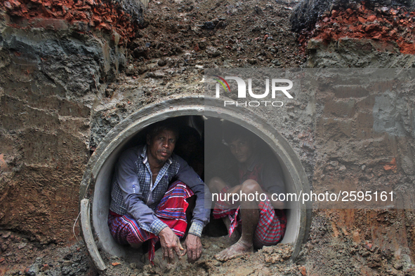 Worker took refuge in an under construction sewerage pipe line while it was raining outside in Dhaka, Bangladesh, on 4 April 2018. 