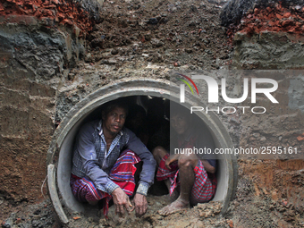 Worker took refuge in an under construction sewerage pipe line while it was raining outside in Dhaka, Bangladesh, on 4 April 2018. (