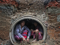 Worker took refuge in an under construction sewerage pipe line while it was raining outside in Dhaka, Bangladesh, on 4 April 2018. (