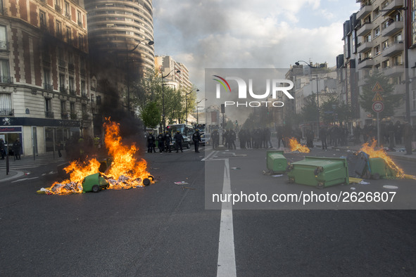 Police stand guard behind burning garbage bins as they face off with protesters near Paris Tolbiac university campus on April 20, 2018 in Pa...