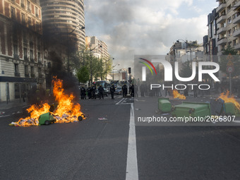 Police stand guard behind burning garbage bins as they face off with protesters near Paris Tolbiac university campus on April 20, 2018 in Pa...