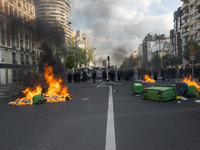 Police stand guard behind burning garbage bins as they face off with protesters near Paris Tolbiac university campus on April 20, 2018 in Pa...