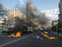 Police stand guard behind burning garbage bins as they face off with protesters near Paris Tolbiac university campus on April 20, 2018 in Pa...