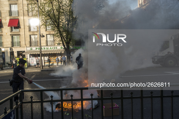 Police stand guard behind burning garbage bins as they face off with protesters near Paris Tolbiac university campus on April 20, 2018 in Pa...