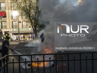 Police stand guard behind burning garbage bins as they face off with protesters near Paris Tolbiac university campus on April 20, 2018 in Pa...