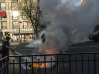 Police stand guard behind burning garbage bins as they face off with protesters near Paris Tolbiac university campus on April 20, 2018 in Pa...