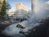 Police stand guard behind burning garbage bins as they face off with protesters near Paris Tolbiac university campus on April 20, 2018 in Pa...