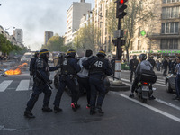 Police stand guard behind burning garbage bins as they face off with protesters near Paris Tolbiac university campus on April 20, 2018 in Pa...