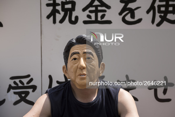 Worker wears a mask of Japanese Prime Minister Shinzo Abe during the May Day rally sponsored by the Japanese Trade Union Confederation, know...