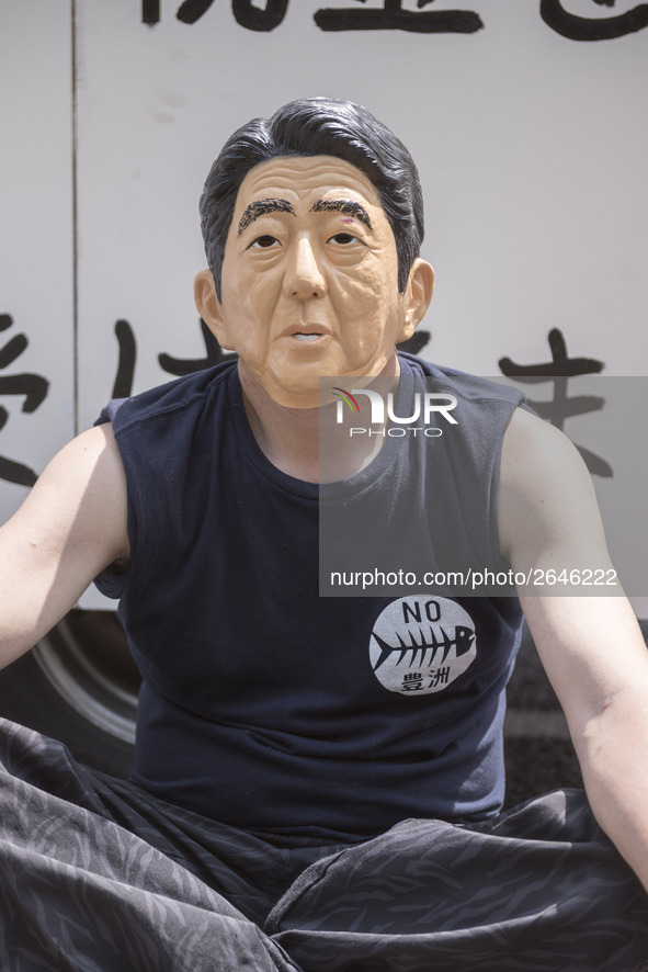 Worker wears a mask of Japanese Prime Minister Shinzo Abe during the May Day rally sponsored by the Japanese Trade Union Confederation, know...