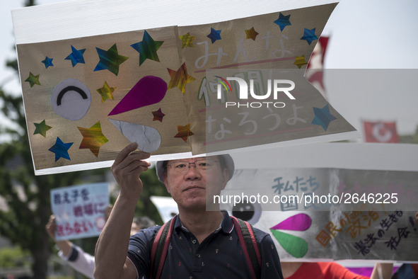 Worker holds placard during the May Day rally sponsored by the Japanese Trade Union Confederation, known as Rengo at Yoyogi Park in Shibuya...