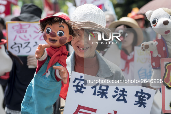 Worker holds placard and puppet during the May Day rally sponsored by the Japanese Trade Union Confederation, known as Rengo at Yoyogi Park...