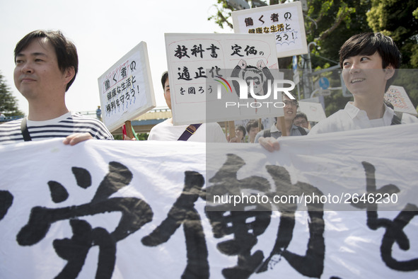 Workers hold placards during the May Day rally sponsored by the Japanese Trade Union Confederation, known as Rengo at Yoyogi Park in Shibuya...