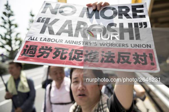 Worker holds placard during the May Day rally sponsored by the Japanese Trade Union Confederation, known as Rengo at Yoyogi Park in Shibuya...