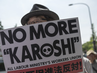 Worker holds placard during the May Day rally sponsored by the Japanese Trade Union Confederation, known as Rengo at Yoyogi Park in Shibuya...