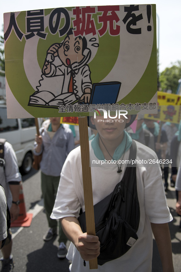 Worker holds placard during the May Day rally sponsored by the Japanese Trade Union Confederation, known as Rengo at Yoyogi Park in Shibuya...