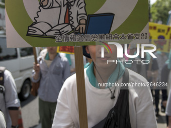 Worker holds placard during the May Day rally sponsored by the Japanese Trade Union Confederation, known as Rengo at Yoyogi Park in Shibuya...