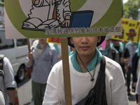 Worker holds placard during the May Day rally sponsored by the Japanese Trade Union Confederation, known as Rengo at Yoyogi Park in Shibuya...