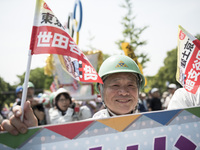 Worker holds placard during the May Day rally sponsored by the Japanese Trade Union Confederation, known as Rengo at Yoyogi Park in Shibuya...