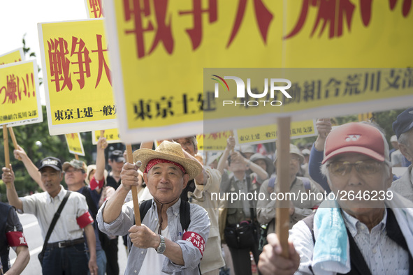 Workers hold placards during the May Day rally sponsored by the Japanese Trade Union Confederation, known as Rengo at Yoyogi Park in Shibuya...