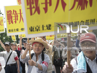 Workers hold placards during the May Day rally sponsored by the Japanese Trade Union Confederation, known as Rengo at Yoyogi Park in Shibuya...