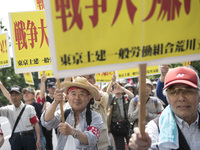 Workers hold placards during the May Day rally sponsored by the Japanese Trade Union Confederation, known as Rengo at Yoyogi Park in Shibuya...