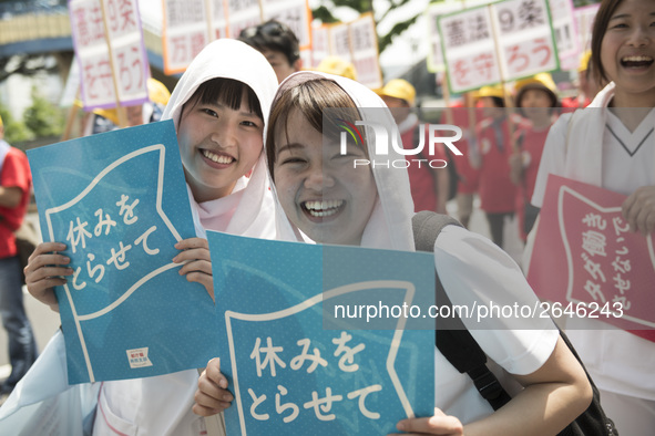 Workers hold placards during the May Day rally sponsored by the Japanese Trade Union Confederation, known as Rengo at Yoyogi Park in Shibuya...