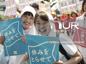 Workers hold placards during the May Day rally sponsored by the Japanese Trade Union Confederation, known as Rengo at Yoyogi Park in Shibuya...