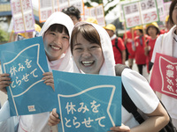 Workers hold placards during the May Day rally sponsored by the Japanese Trade Union Confederation, known as Rengo at Yoyogi Park in Shibuya...